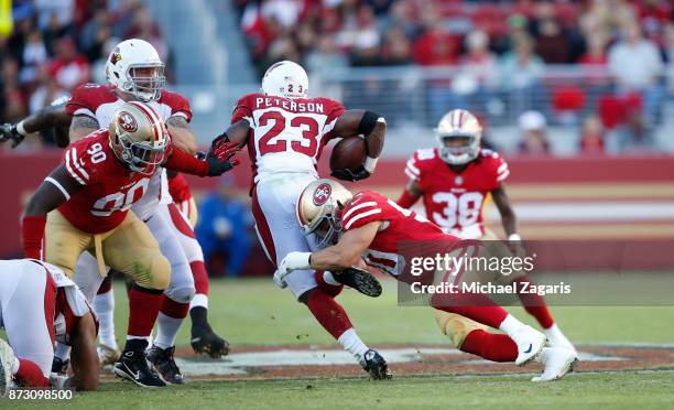 Brock Coyle of the San Francisco 49ers tackles Adrian Peterson of the Arizona Cardinals during the game at Levi's Stadium on November 5, 2017 in...