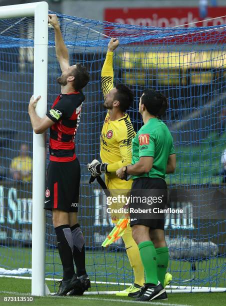 Robert Cornthwaite of the Wanderers and Western Sydney goalkeeper Verdran Janjetovic are asked by the officials to reattach the a part of the goal...