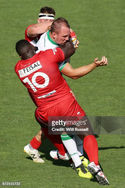 George King of Ireland is tackled by Philip Joseph and Morgan Knowles of Wales during the 2017 Rugby League World Cup match between Wales and Ireland...