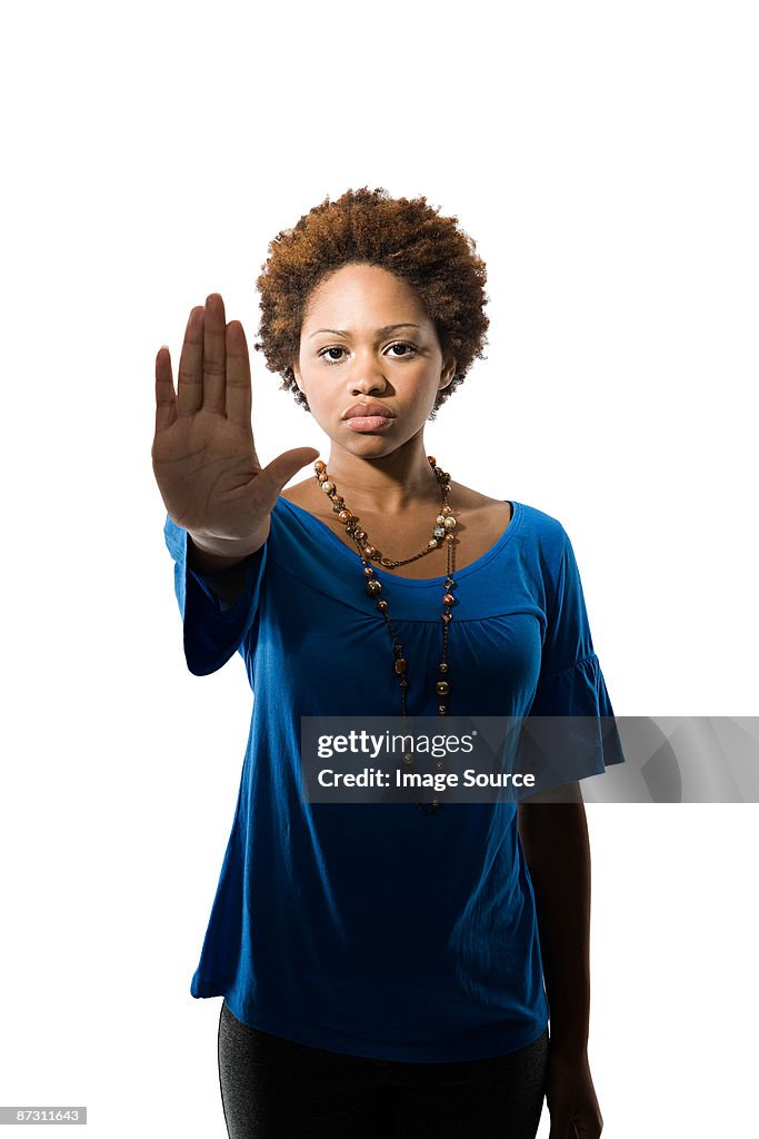 Portrait of a young woman with her hand raised