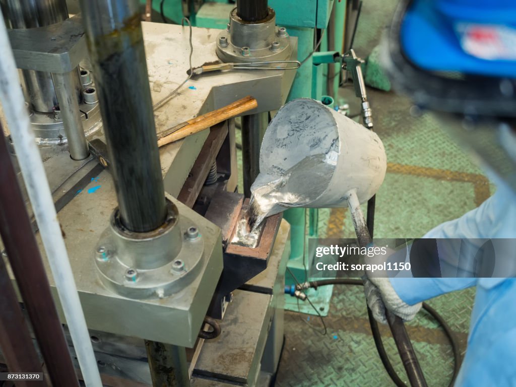 Operator pouring aluminum molten in to high precision casting mold