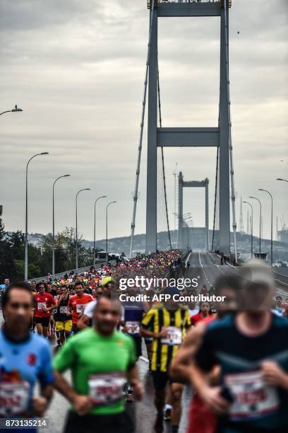 Participants run on the July 15 Martyrs' Bridge, known as the Bosphorus Bridge, during the 39th annual Istanbul Marathon on November 12 in Istanbul....