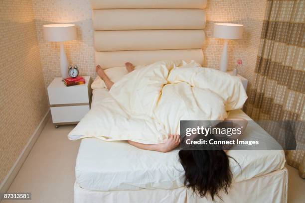 woman upside down in bed - down comforter stock pictures, royalty-free photos & images