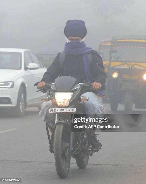 Indian commuters make their way through heavy smog in Amritsar on November 12, 2017. Large swathes of north India and Pakistan see a spike in...