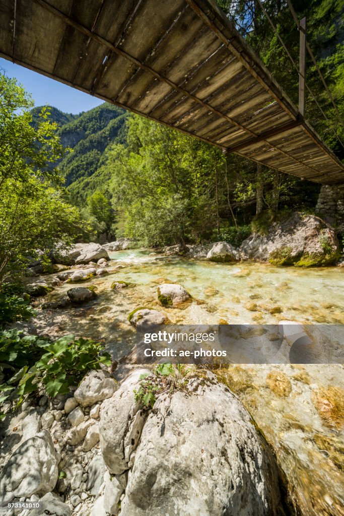 Hölzerne Hängebrücke über Soča unter blauem Himmel im Sommer