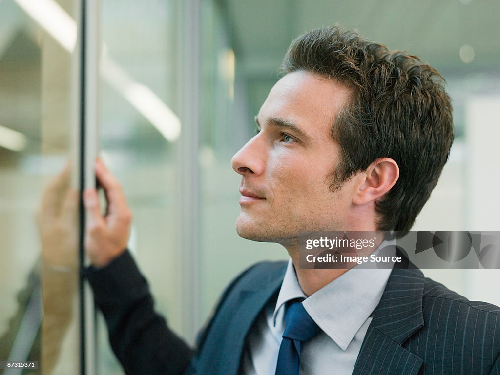 Businessman looking through window