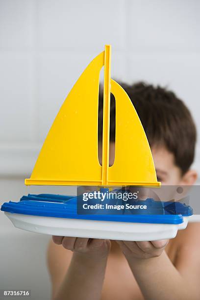 boy holding a toy boat - kinder badeboot stock-fotos und bilder