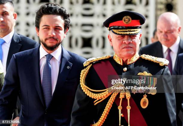 Jordan's King Abdullah II , accompanied by Crown Prince Hussein bin Abdullah II , reviews the honour guard upon his arrival at parliament, as he...