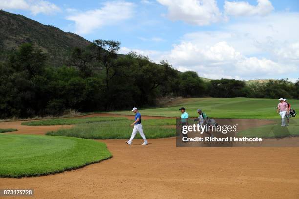 Martin Kaymer of Germany and Francesco Molinari of Italy cross a bunker on the 14th hole during the final round of the Nedbank Golf Challenge at Gary...