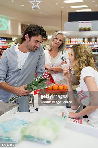 man flirting with sales assistant - supermarket queue stock pictures, royalty-free photos & images