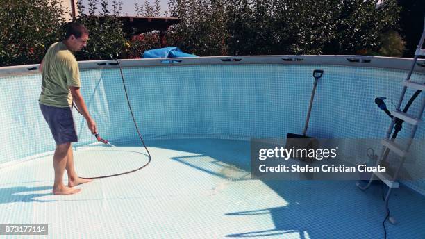 man cleaning the pool in autumn - swimming pool cleaning stock pictures, royalty-free photos & images