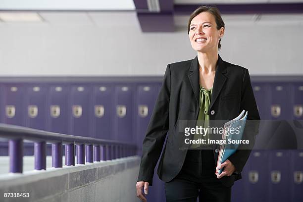 a teacher walking down a corridor - school principal 個照片及圖片檔