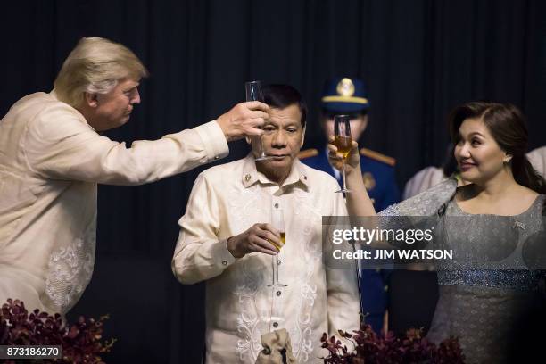 Philippine President Rodrigo Duterte stands as his partner Honeylet Avancena toasts US President Donald Trump during a special gala celebration...