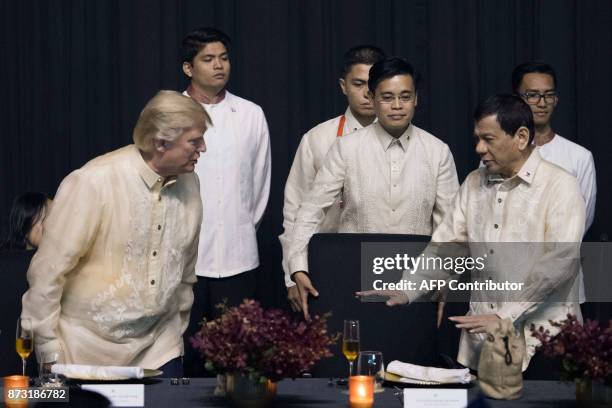 Philippine President Rodrigo Duterte gestures towards US President Donald Trump during a special gala celebration dinner for the Association of...