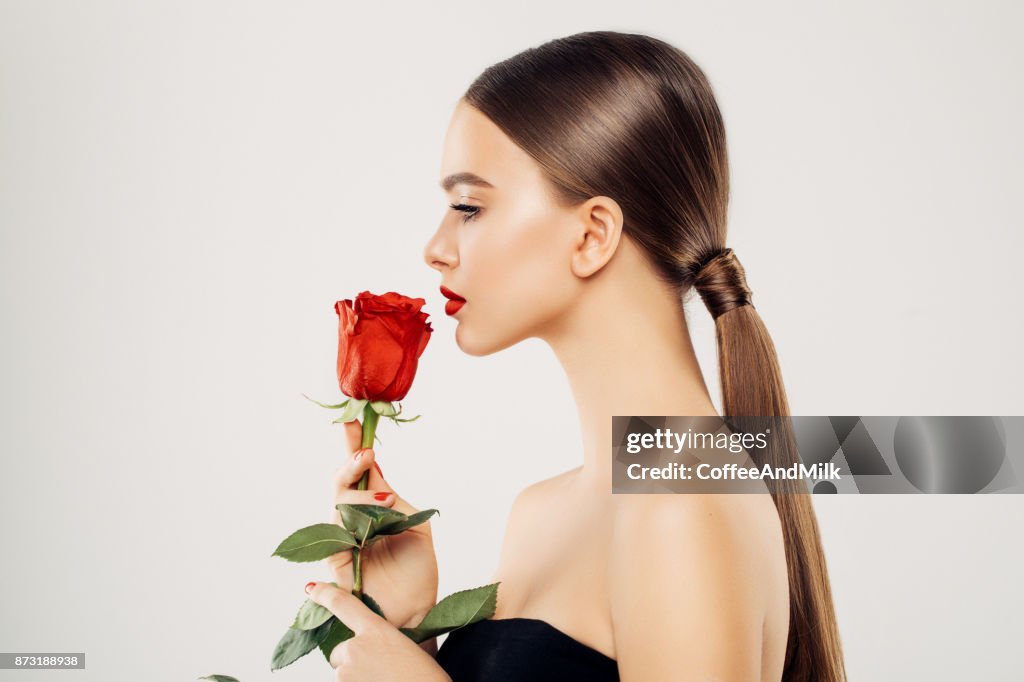 Belle fille avec une rose rouge