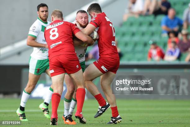 Brad Singleton of Ireland is tackled by Craig Kopczak and Joe Burke of Wales during the 2017 Rugby League World Cup match between Wales and Ireland...