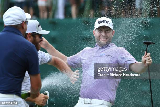 Branden Grace of South Africa is sprayed with champagne after his victory on the 18th green during the final round of the Nedbank Golf Challenge at...