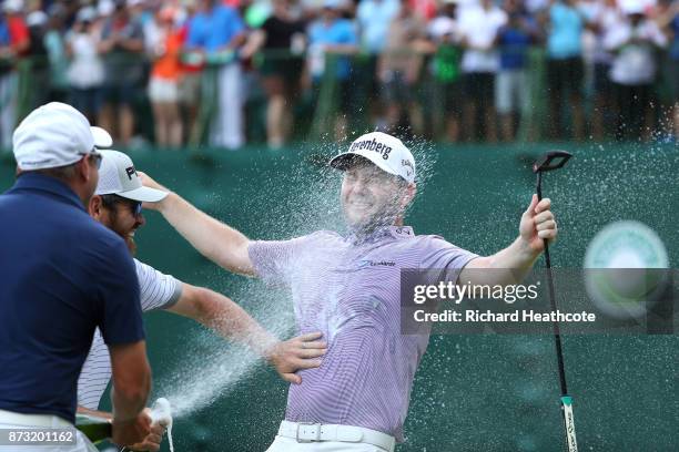 Branden Grace of South Africa is sprayed with champagne after his victory on the 18th green during the final round of the Nedbank Golf Challenge at...