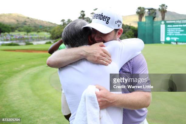 Branden Grace of South Africa is congratulated by Gary Player on the 18th green during the final round of the Nedbank Golf Challenge at Gary Player...