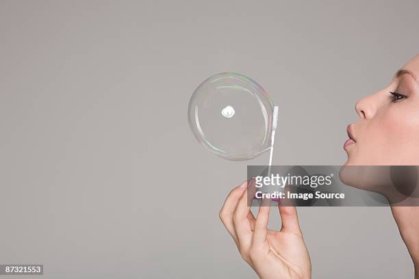 young woman blowing a bubble - blowing a kiss imagens e fotografias de stock