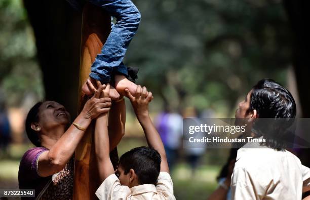 Children helping a child as he tries to climb on a Mallakhamb pole during Makkala Hanna, Children Festival at Cubbon Park, on November 12, 2017 in...
