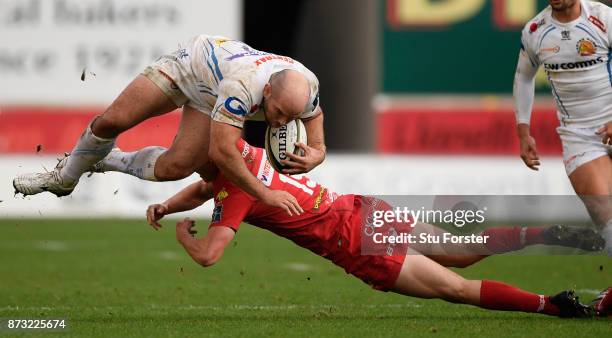 Chiefs hooker Shaun Malton goes over the tackle of Morgan Williams during the Anglo Welsh Cup match between Scarlets and Exeter Chiefs at Parc y...