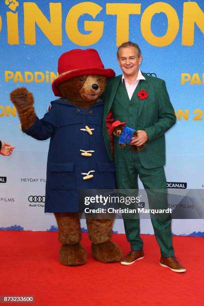 Hugh Bonnevilie stands next to the film character Paddington as he attends the 'Paddington 2' premiere at Zoo Palast on November 12, 2017 in Berlin,...
