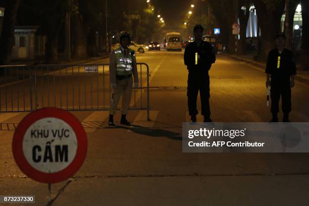 Policemen stand guard at a road block outside the venue of a state banquet to welcome China's President Xi Jinping in Hanoi on November 12, 2017. /...