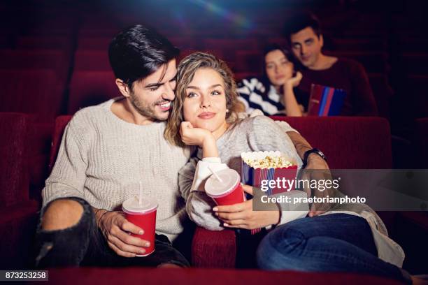 couple is watching romantic movie in the cinema theater - young couple at movie together imagens e fotografias de stock
