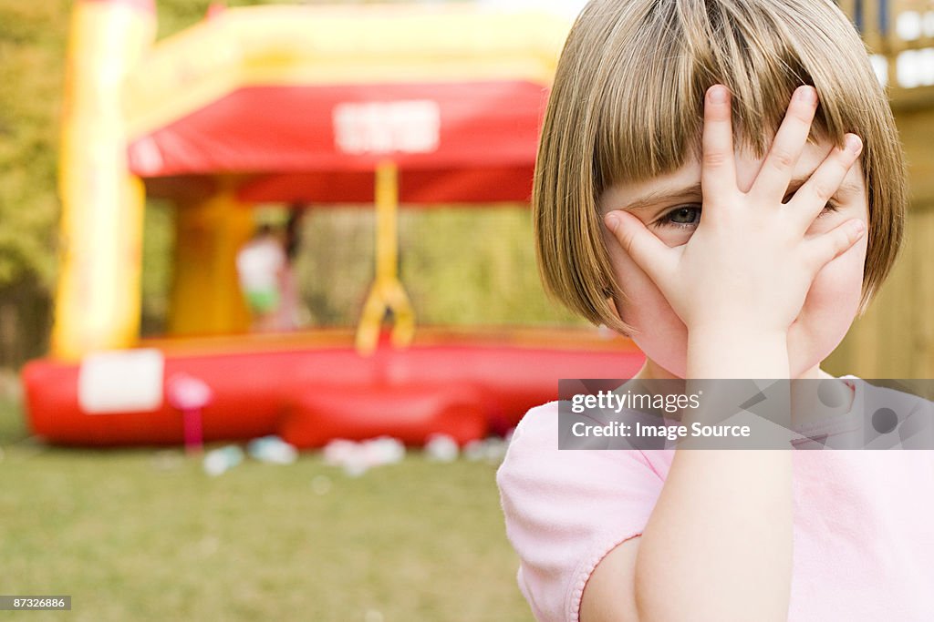 Girl with hand in front of face