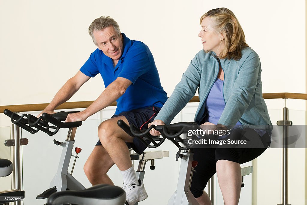 A man and woman using exercise bikes
