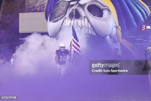 East Carolina Pirates wide receiver Ockwan Tyson-Hart carries the American Flag onto the field during pre-game activities during a college football...