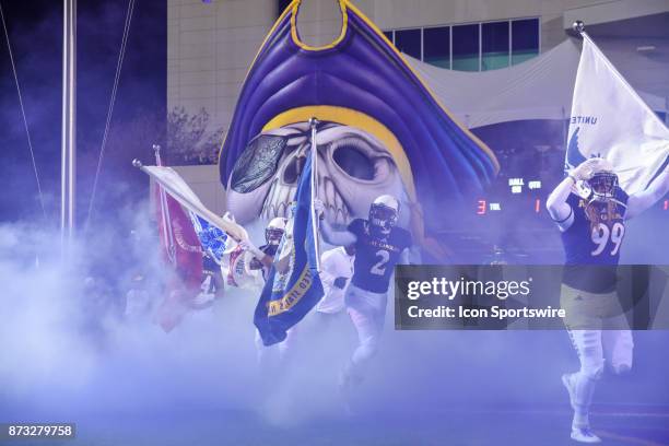 East Carolina Pirates tight end Dalton Montgomery and East Carolina Pirates quarterback Kingsley Ifedi carry the flags onto he field during pre-game...