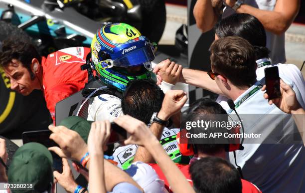 Williams' Brazilian driver Felipe Massa greets people after his final home city race at the end of the Brazilian Formula One Grand Prix, at the...