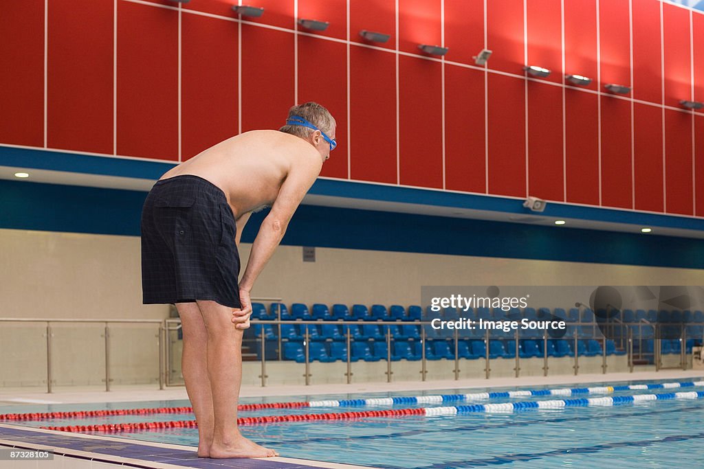 A mature man about to dive into a swimming pool