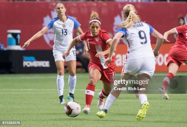 Desiree Scott of Canada tries to dribble the ball past Alex Morgan and Lindsey Horan of the United States during International Friendly soccer match...