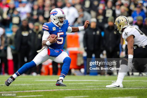 Tyrod Taylor of the Buffalo Bills runs with the ball as Marcus Williams of the New Orleans Saints attempts to defend him during the first quarter on...