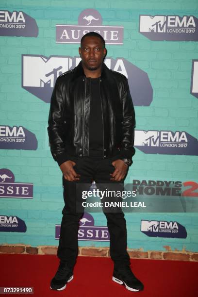 British hip-hop artist Dizzee Rascal poses on the red carpet arriving to attend the 2017 MTV Europe Music Awards at Wembley Arena in London on...