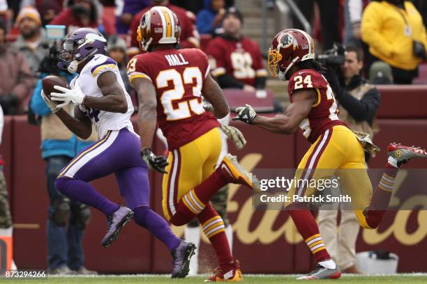 Wide receiver Stefon Diggs of the Minnesota Vikings makes a catch past free safety DeAngelo Hall of the Washington Redskins during the first quarter...