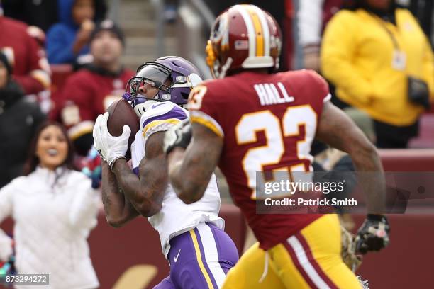 Wide receiver Stefon Diggs of the Minnesota Vikings makes a catch past free safety DeAngelo Hall of the Washington Redskins during the first quarter...