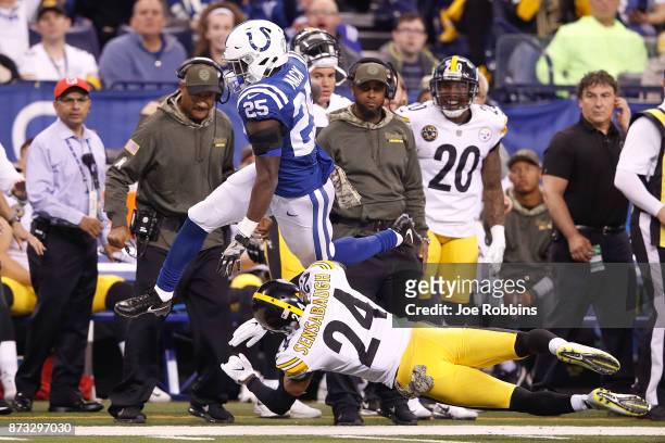 Marlon Mack of the Indianapolis Colts leaps over Coty Sensabaugh of the Pittsburgh Steelers during the second quarter at Lucas Oil Stadium on...