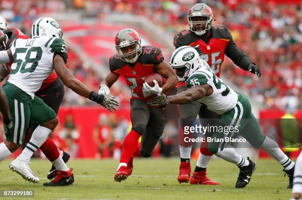 Running back Doug Martin of the Tampa Bay Buccaneers finds room to run between inside linebacker Darron Lee of the New York Jets and outside...