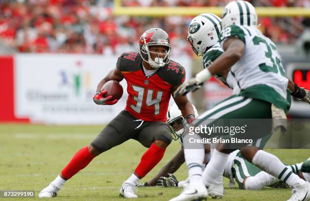 Running back Charles Sims of the Tampa Bay Buccaneers evades inside linebacker Demario Davis of the New York Jets and cornerback Juston Burris during...