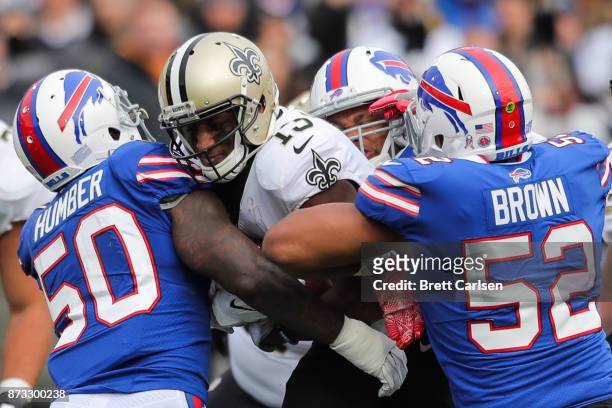Michael Thomas of the New Orleans Saints runs with the ball as Ramon Humber of the Buffalo Bills, Lorenzo Alexander of the Buffalo Bills and Preston...