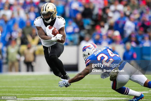 Alvin Kamara of the New Orleans Saints runs the ball as Leonard Johnson of the Buffalo Bills attempts to tackle him during the first quarter on...