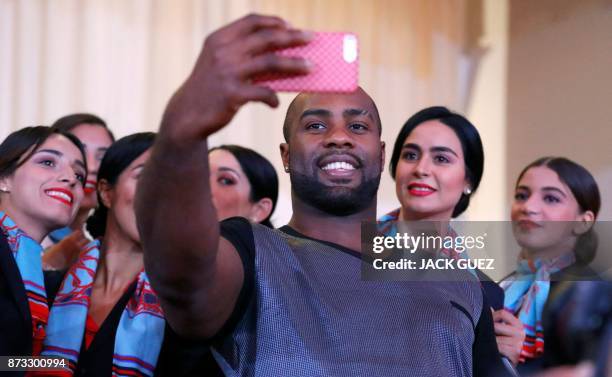 French judoka Teddy Riner takes a selfie with hostesses after his victory in the Judo World Championships Open in Marrakesh on November 12, 2017. -...