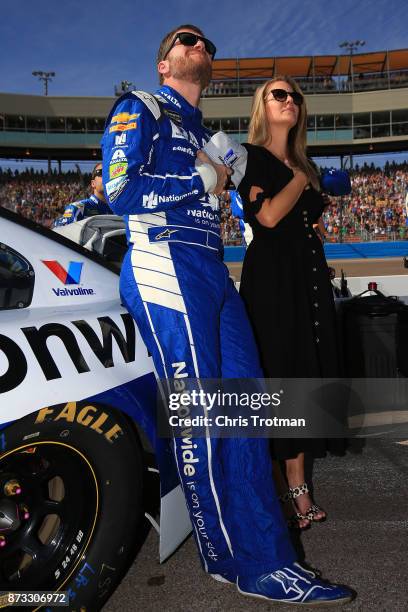 Dale Earnhardt Jr., driver of the Nationwide Chevrolet, and his wife Amy stand during the national anthem prior to the Monster Energy NASCAR Cup...