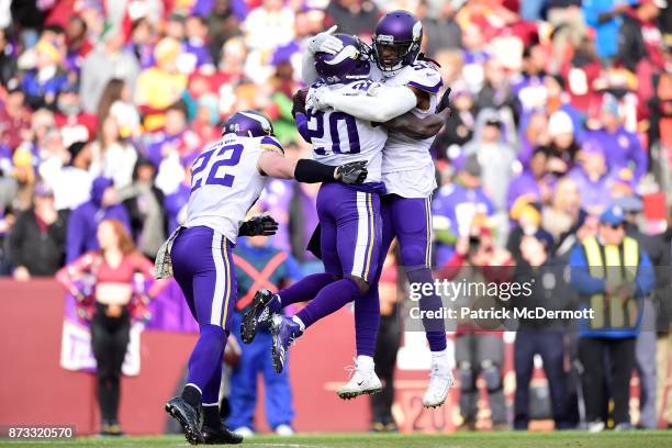 Cornerback Mackensie Alexander of the Minnesota Vikings celebrates with Harrison Smith and Emmanuel Lamur after an interception during the second...