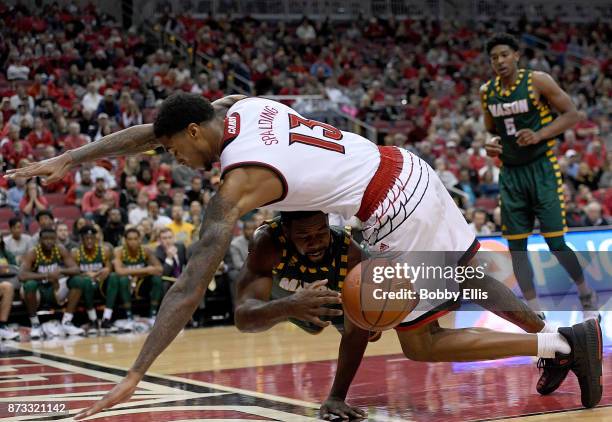 Ian Boyd of the George Mason Patriots passes the ball under Ray Spalding of the Louisville Cardinals during the first half of the game between the...