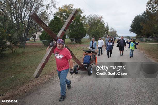 Stephen Hope pulls a cross through town followed by other worshipers after leaving Sunday service at the temporary First Baptist Church of Sutherland...